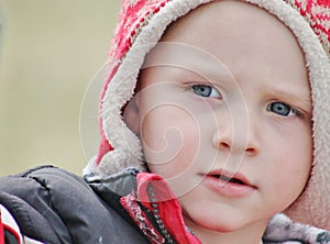 Adorable toddler boy close up in a winter hat