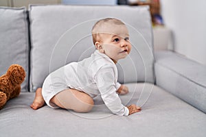 Adorable toddler crowling on sofa at home