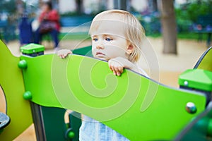 Adorable toddler feeling sad on playground