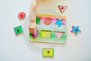 Adorable toddler girl doing wooden puzzle