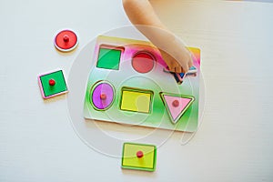 Adorable toddler girl doing wooden puzzle