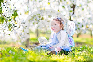 Adorable toddler girl in fairy costume in fruit garden