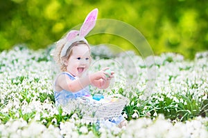 Adorable toddler girl with first white spring flowers