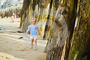 Adorable toddler girl having fun on Sillon beach in Saint-Malo, Brittany, France photo