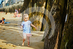 Adorable toddler girl having fun on Sillon beach in Saint-Malo, Brittany, France photo