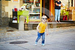 Adorable toddler girl having fun on a street of medieval town of Quimper  Brittany  France