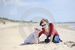 Adorable toddler girl and her mother on a beach