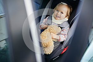 Adorable toddler girl in modern car seat