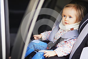 Adorable toddler girl in modern car seat