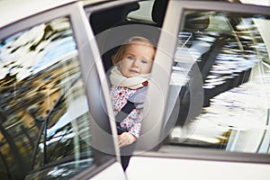 Adorable toddler girl in modern car seat