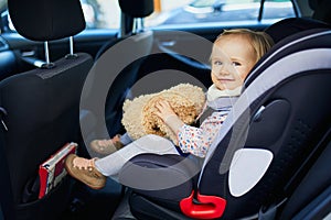 Adorable toddler girl in modern car seat