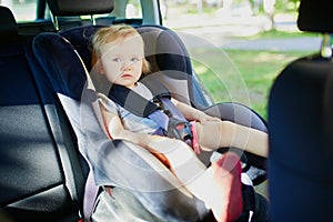 Adorable toddler girl in modern car seat
