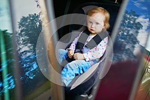 Adorable toddler girl in modern car seat