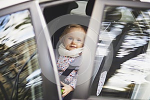 Adorable toddler girl in modern car seat