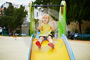 Adorable toddler girl on playground slide