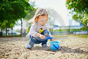 Adorable toddler girl playing with bucket and shovel