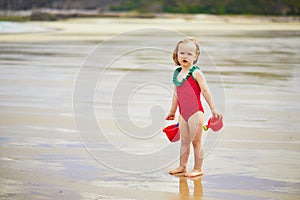 Adorable toddler girl playing on the sand beach at Atlantic coast of Brittany, France