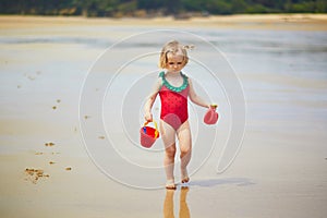 Adorable toddler girl playing on the sand beach at Atlantic coast of Brittany, France
