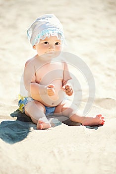Adorable toddler girl playing on white sand beach