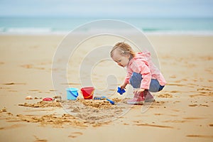 Adorable toddler girl on the sand beach at Atlantic coast of Brittany  France