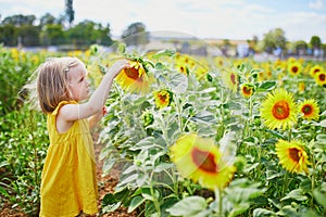 Adorable toddler girl on sunflower field