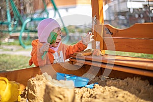 Adorable toddler playing in the sandbox. cute child in fox pajamas plays in the sand. portrait of a happy baby