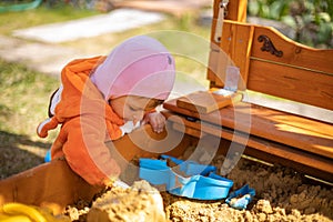 adorable toddler playing in the sandbox. cute child in fox pajamas plays in the sand. portrait of a happy baby