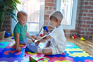 Adorable toddlers playing around lots of toys at kindergarten