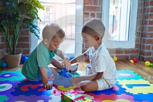 Adorable toddlers playing around lots of toys at kindergarten photo