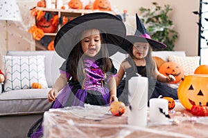 Adorable twin girls having halloween party smiling confident at home