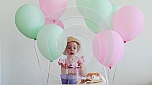 Adorable two years old birthday girl in summer clothes trying to put sunglasses on her head