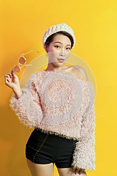 Adorable woman expressing true positive emotions during photoshoot in pink fur coat. Indoor portrait of active glamorous girl