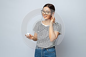 Adorable woman student checking earphones enjoying sounds