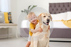 Adorable yellow labrador retriever and little boy