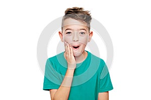 Adorable young boy in shock, isolated over white background. Shocked child looking at camera in disbelief. Shock, amazement.