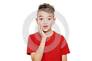 Adorable young boy in shock, isolated over white background. Shocked child looking at camera in disbelief. photo