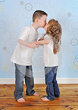 Adorable young brother and sister sharing a kiss