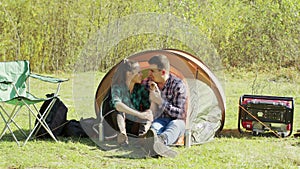 Adorable young couple having a sweet moment in camping tent