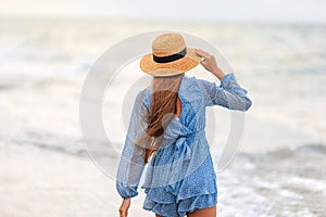 Adorable young girl with beautiful long hair enjoy tropical beach vacation. The girl on the seashore at sunset