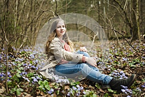 Adorable young girl hiking in the woods on beautiful spring day. Teenager portrait in spring park