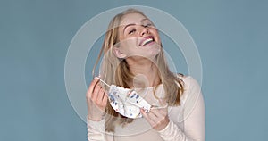 Adorable young girl taking off her face mask against viuses with huge relief.