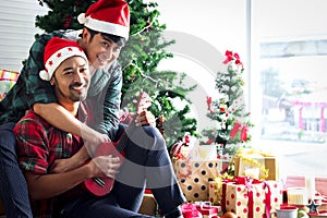 Adorable young LGBT couple sharing special moment together on Christmas holiday, Asian gay male lover sitting in living room,