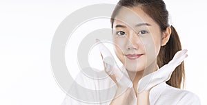 Adorable young woman washing her face with foam soap in hand while standing over isolated white background. Skin care and