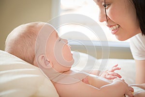 Adoring Mixed Race Chinese and Caucasian Baby Boy Laying In Bed with His