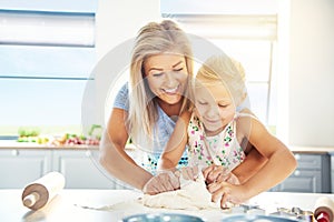 Adoring young mother teaching her daughter to bake