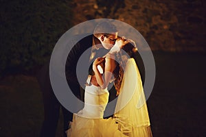 Adorning elegant fashion groom and bride is kissing on the back