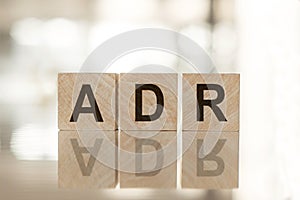 ADR - financial concept on a blur background. Wooden cubes