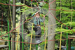 Active Young Child Climbing in Adrenaline Rope Playground
