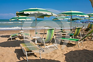 Adriatic Sea coast view. Seashore of Italy, summer umbrellas on sandy beach with clouds on horizon.