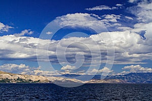 Adriatic sea, mountains and hills. Blue sky with white clouds